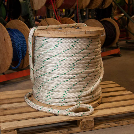 A coil of brown manila rope cable in normal light put on the dark brown  color hardwood gross surface represent the pattern and roughly external  surface of rope Stock Photo